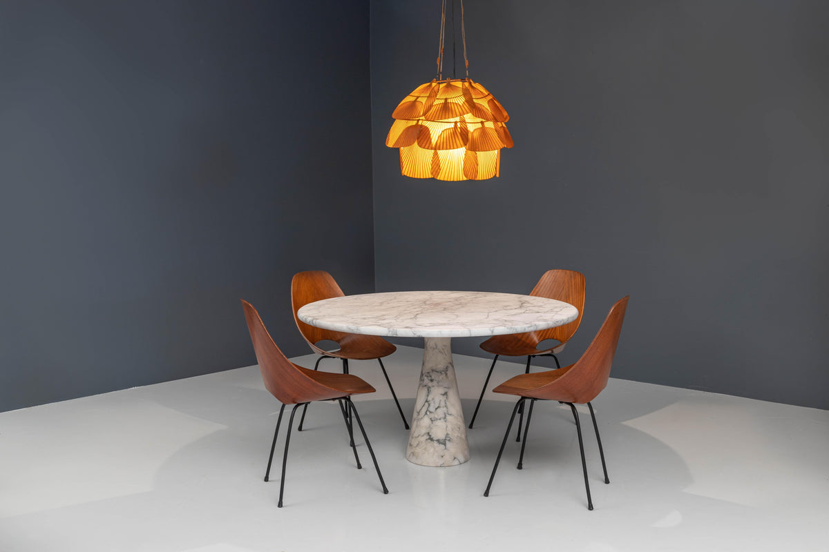 Four Medea dining chairs by Vittorio Nobili around a round marble table under a paper fan pendant lamp